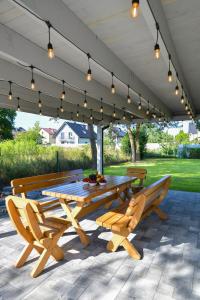 a picnic table and benches under awning with lights at Magic Apartments - Aroma Zator in Zator