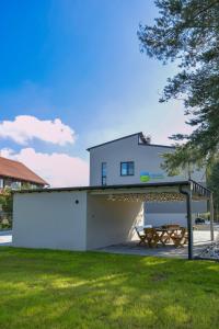 a white building with a picnic table in a yard at Magic Apartments - Aroma Zator in Zator