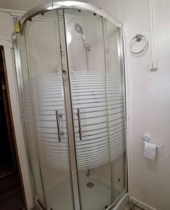 une douche avec une cabine en verre dans une salle de bain dans l'établissement Cabaña muy confortable con buena ubicación y acceso, à Puerto Montt