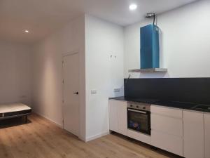 Una cocina con gabinetes blancos y una encimera negra. en Apartamento Cienciasmar, en Valencia