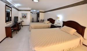 a hotel room with two beds and a desk at Ex Hotel Asturias Centrico in Santa Cruz de la Sierra