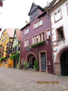 a group of colorful buildings on a street at Le B. Suites, Chambres & Restaurant in Riquewihr