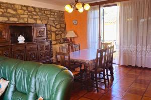 a living room with a table and a green couch at L'Oustal 3 chambres avec grand jardin parking gratuit in Bram