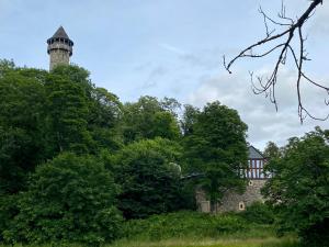 an old house with a lighthouse on top of trees at Ferienwohnung an der Wildenburg in Kempfeld