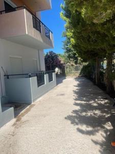 a sidewalk next to a white building with a tree at Adriana`s Ammoudara apts in Amoudara Herakliou