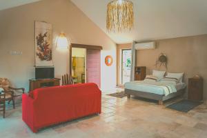 a living room with a bed and a red couch at La Kaz Venelle in Saint-Pierre