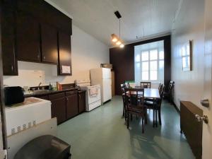 a kitchen with a table and chairs and a kitchen with aearcher at Auberge du Couvent in Saint-Casimir