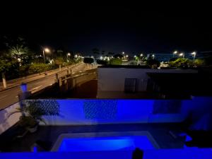 a night view of a building with blue lights at The Yumbo Pearl in Playa del Ingles