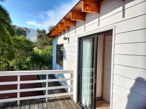 a house with a balcony with a door at Hospedaje "EL colorado" in Zapallar +11 photos