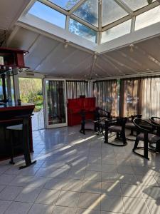 a room with a conservatory with tables and a piano at Hotel Athina in Asprovalta