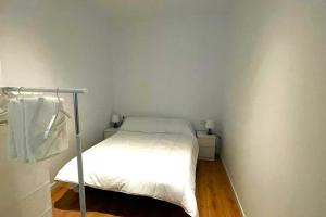 Un pequeño dormitorio con una cama blanca en una habitación en Apartamento Cienciasmar, en Valencia