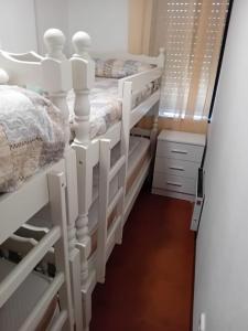 a room with two white bunk beds in it at Estupendo apartamento en San Vicente do Mar O Grove in San Vicente do Mar +12 photos