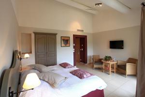 a bedroom with a large bed and a living room at Le Domaine de Saint Endreol Golf & Spa Resort in La Motte