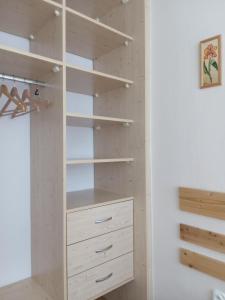 una cabina armadio con armadi bianchi e scaffali di Gyöngy Apartman a Zalaegerszeg