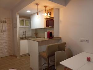 Una pequeña cocina con encimera, sillas y una mesa. en Apartamento Júpiter - Minerva, en Benalmádena