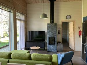 a living room with a green couch and a fireplace at Villa Fox Ruka in Ruka