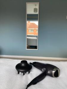 a hairbrush laying on a bed in front of a mirror at Cosy at Cumberland - Double room with shared bathroom in Dundonald