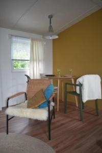 エーペにあるChalet onder de Eikの椅子とテーブルのあるリビングルーム