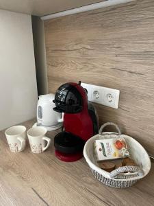a coffee maker next to two cups and a basket at Comfy home 2 - Burgas Centre in Burgas City