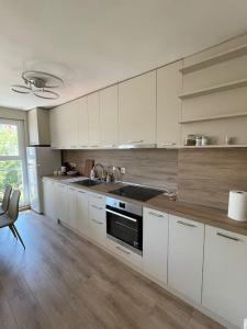 a kitchen with white cabinets and a sink at Comfy home 2 - Burgas Centre in Burgas City