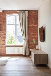 a living room with a brick wall and a window at Rossak apartment 1 in Panevėžys