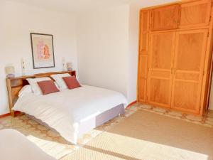 een slaapkamer met een wit bed en een houten kast bij Lemon in Casaglione