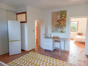 een keuken met een bureau en een schilderij aan de muur bij Lemon in Casaglione +14 foto's