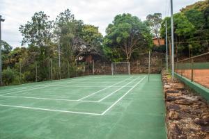 una pista de tenis con una red en Pousada Fazenda Monjolos, en Serra do Cipo