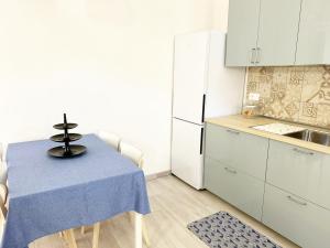 Casa Giannina a Marina di Cecina by Zoom In Earth في مارينا دي سيسينا: مطبخ صغير مع طاولة وثلاجة