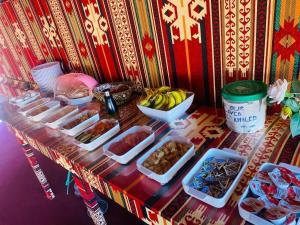 a table with bowls of food and a bowl of bananas at Msek wadi rum camp in Disah