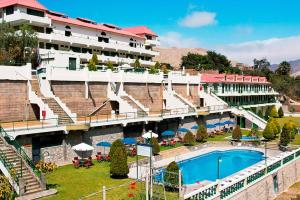a hotel with a swimming pool in front of a building at Villasol Hotel in Lunahuaná +12 photos