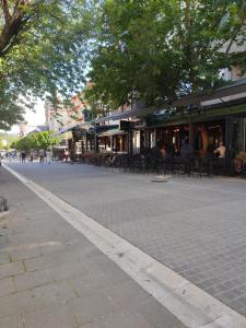 une rue pavée avec des tables et des chaises en face d'un bâtiment dans l'établissement Pesacka Zona Apartment, à Novi Pazar