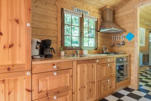 a kitchen with wooden cabinets and a stove at Fantastisch chalet met veel ruimte en fijne tuin in Epe