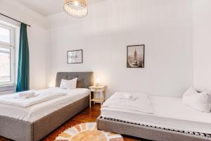 two beds in a room with white walls at Hopfenhaus Kulmbach in Kulmbach