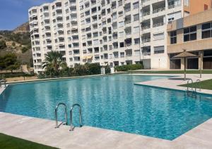 a large swimming pool in front of a building at Perfecto Apartamento para vacaciones frente al mar in Villajoyosa