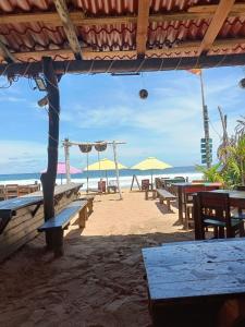 a beach with tables and umbrellas and the ocean at La Máxima Drag Show & Bar LGBT in Zipolite