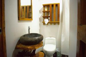 a bathroom with a rock sink and a toilet at Sanagua Cascadas del Lavapatas in San Agustín +33 photos
