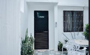 Una puerta negra en una casa blanca con una mesa y sillas. en Ocean View Paradise in Puerto Galera, en Puerto Galera
