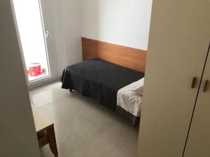a small bedroom with a bed and a window at Appartamento fronte mare Pesaro in Pesaro
