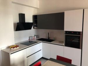 a kitchen with white cabinets and black appliances at Appartamento fronte mare Pesaro in Pesaro +8 photos