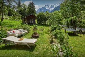 a garden with a couch and a table in the grass at Chalet La Chandelle - OVO Network in Bionnassay