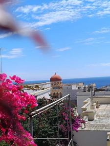 vistas a un edificio con una torre de reloj y flores en Adelè posto tranquillo al centro del paese, en Santa Cesarea Terme