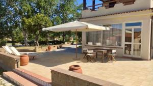 a patio with a table and an umbrella at Podere Il Ritorno in Portoferraio