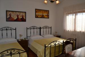 ein Schlafzimmer mit 2 Betten und einem Wandgemälde in der Unterkunft Hotel Canusium in Canosa di Puglia