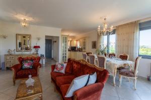 a living room with a table and red chairs at 3-BR Sea View Villa with Garden in Mytilene in Mytilini