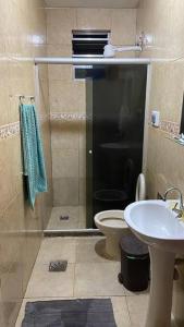 um banheiro com chuveiro, vaso sanitário e pia em Casa em Cabo Frio próximo à praia - Mar e Sol em Cabo Frio