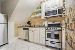 een keuken met witte kasten en roestvrijstalen apparaten bij Villa Mulvey #1 in St. Augustine