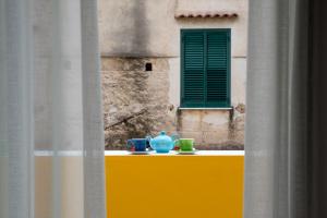 two cups on a yellow table with a window at Amalfi Luxury House in Amalfi