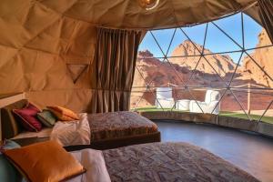 a room with two beds and a large window at Msek wadi rum camp in Disah