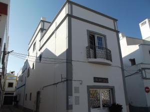 Edificio blanco con puerta y balcón en Family Floripes House, en Olhão